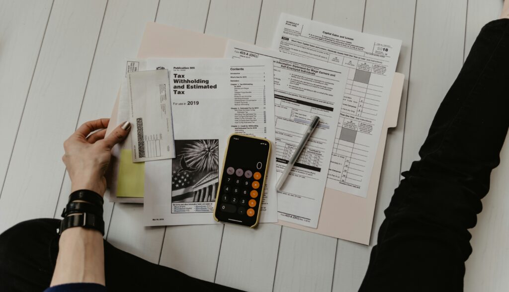 Documents financiers et calculatrice sur une table, préparation de déclarations et gestion comptable